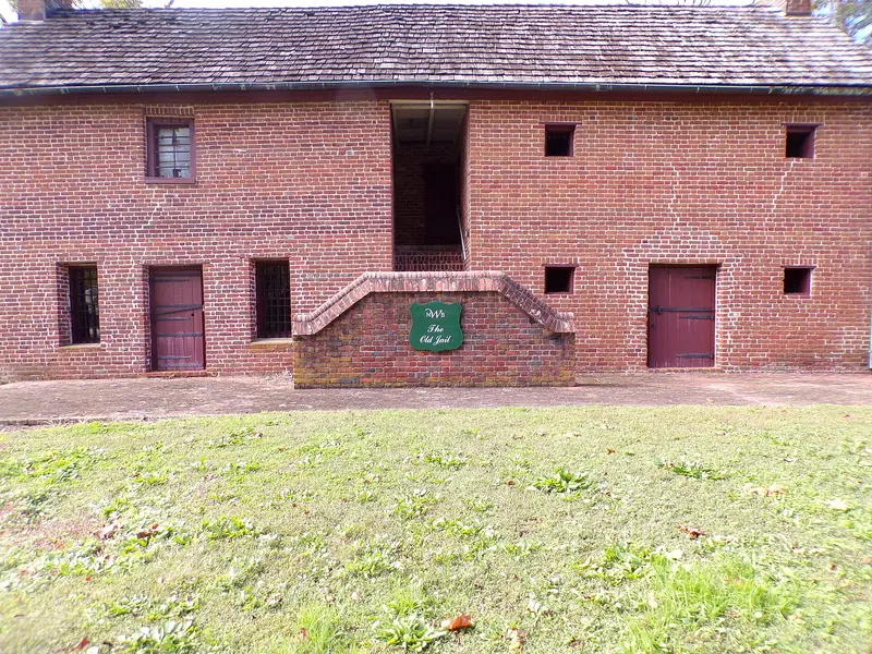 The brick Old Jail in Lancaster, SC, with barred windows and a sign reading The Old Jail